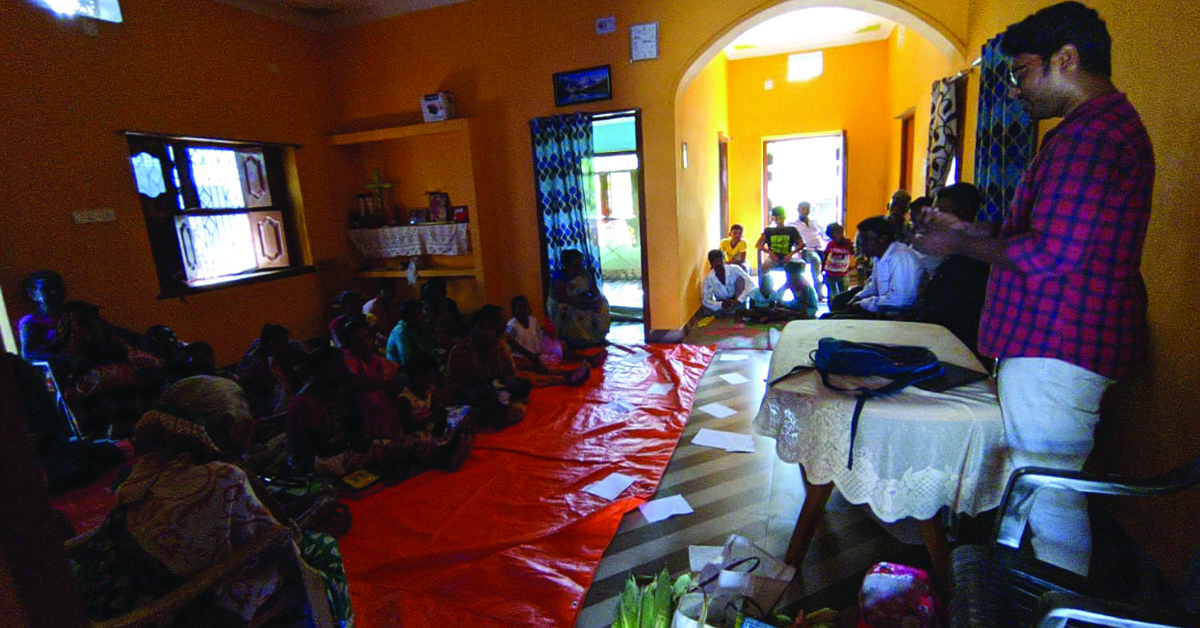 a TCD worker having an indoor meeting with Indian villagers