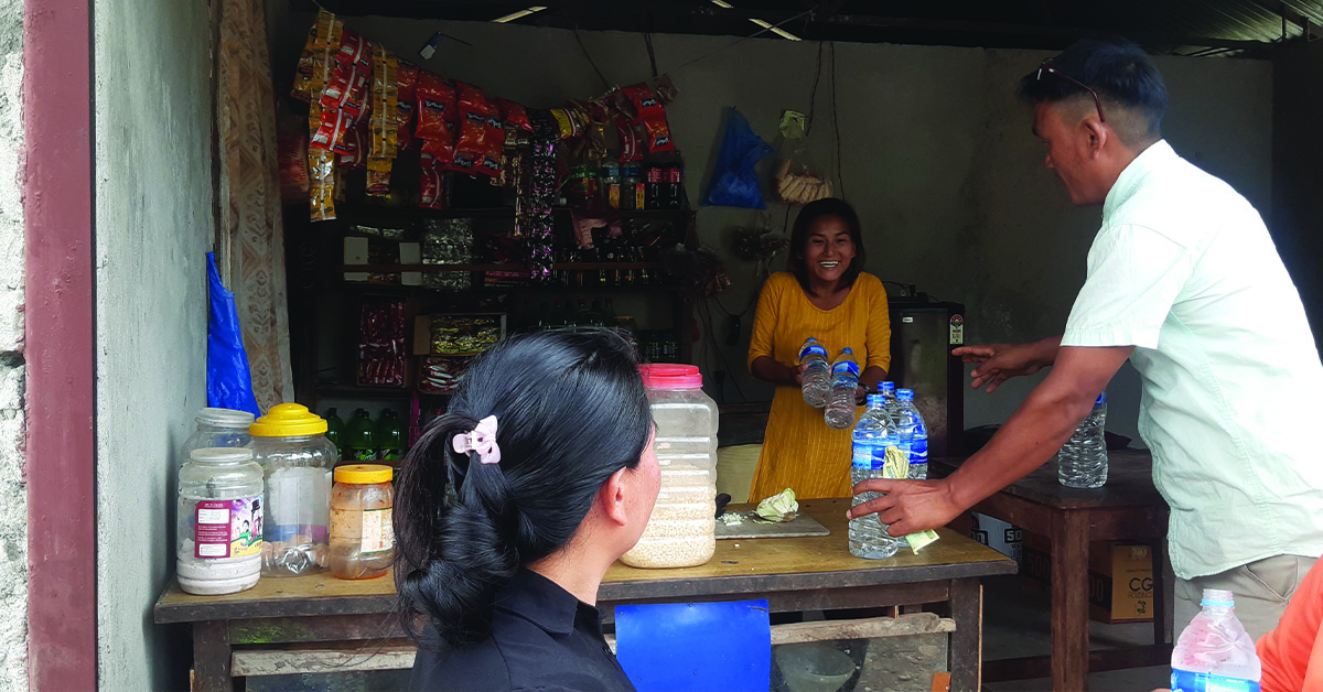 A villager buying water from a Nepal business woman.