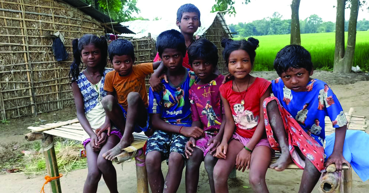 A group of village children on a bench.