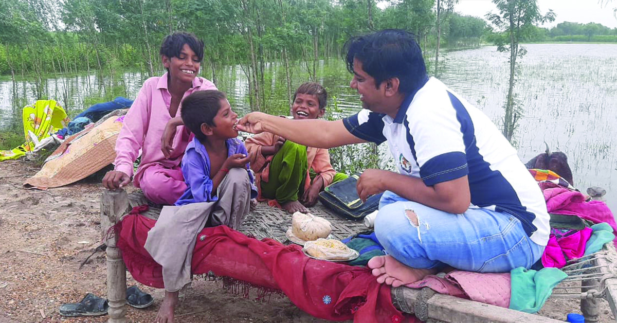 TCD worker, Salim, feeding a smiling child