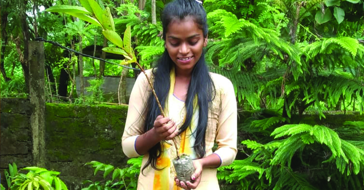 An India woman holding a fruit plant.