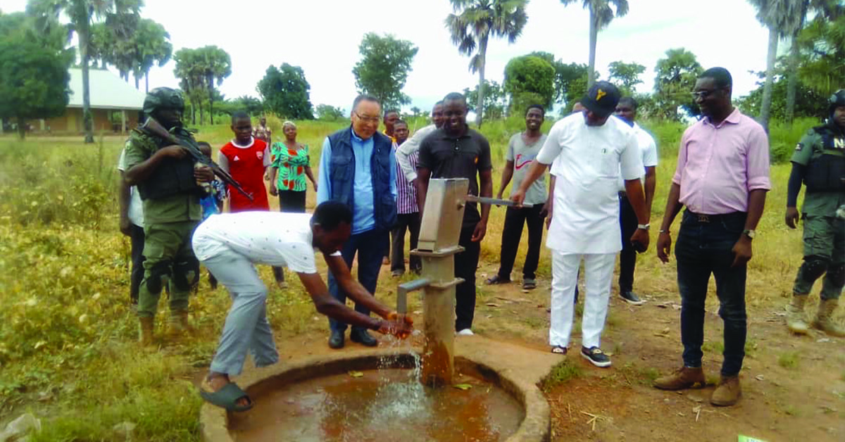 TCD Supporter, John, seeing Ahumbe villagers work on a borehole.