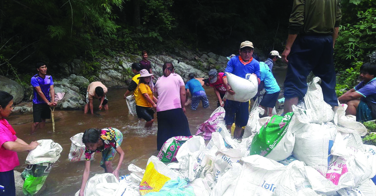 Thailand villagers fixing their flooded road.