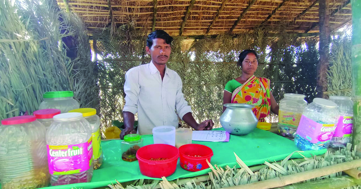 A husband and wife standing in their small business hut.