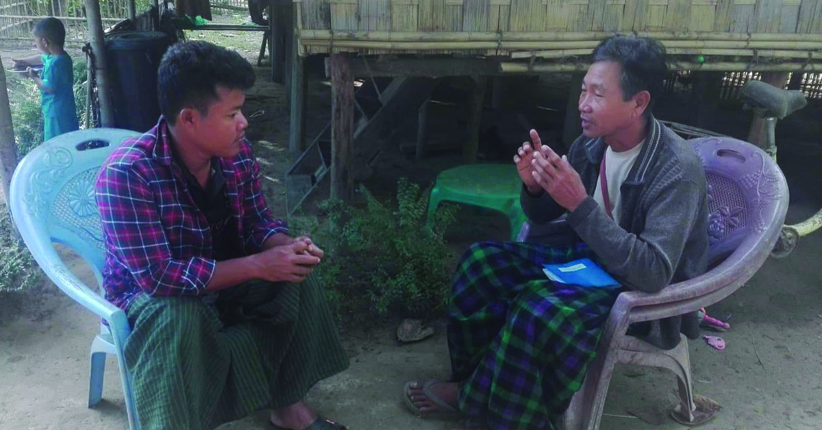Myanmar Champion talking to one of his fellow villagers.