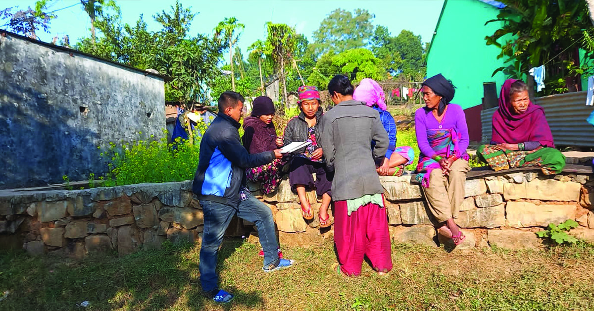 A Nepal TCD Leader showing papers to a group of female villagers.