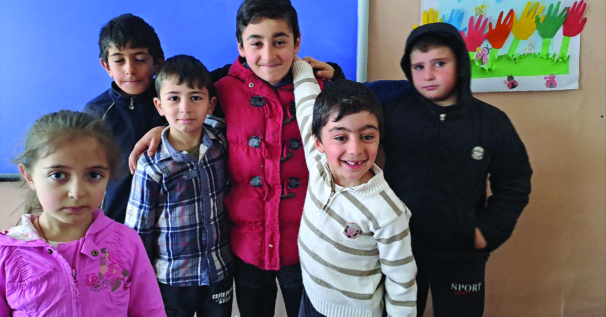 A gorup of kids smiling after receiving toothpaste and a toothbrush.