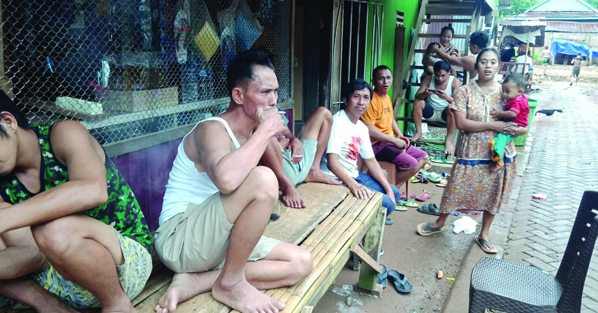 Village males sitting outdoors.