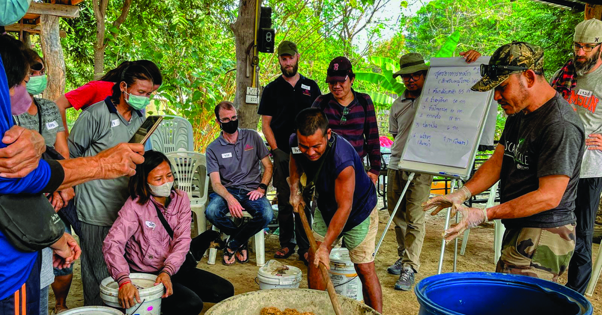 The Thailand community learning how to make their own pig feed.