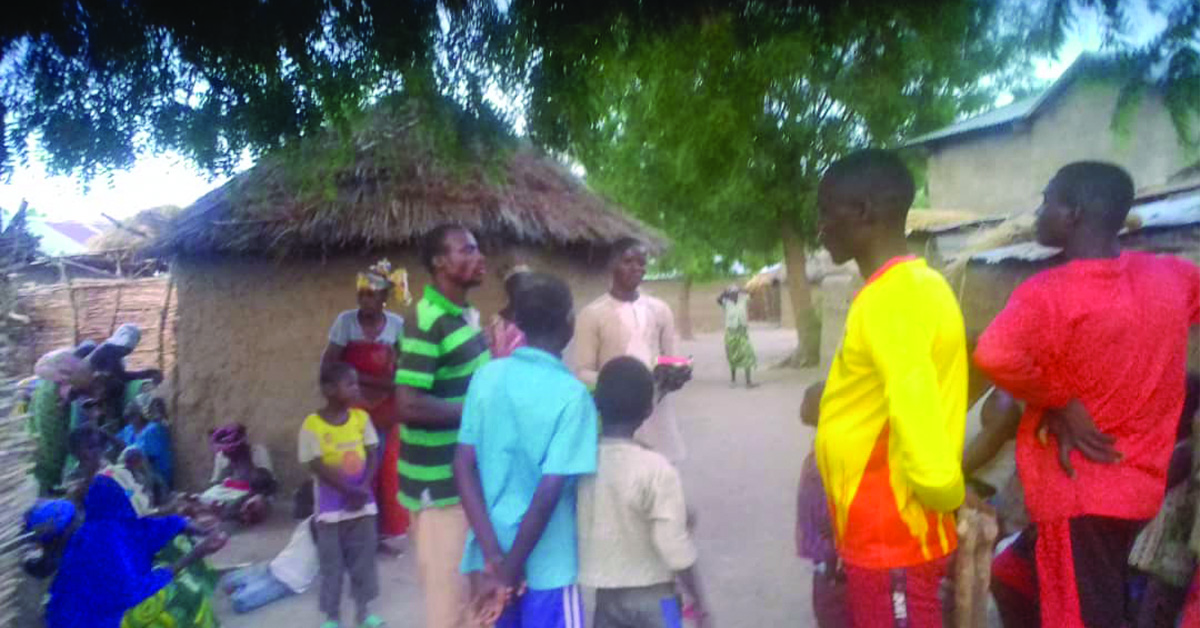 A group of Cameroon villagers outdoors in their village.