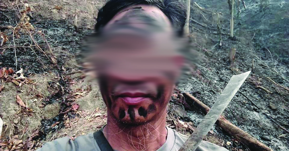 A Myanmar man in front of a burnt plantation field.