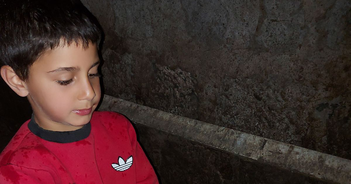 An Armenian boy holding a chicken egg.