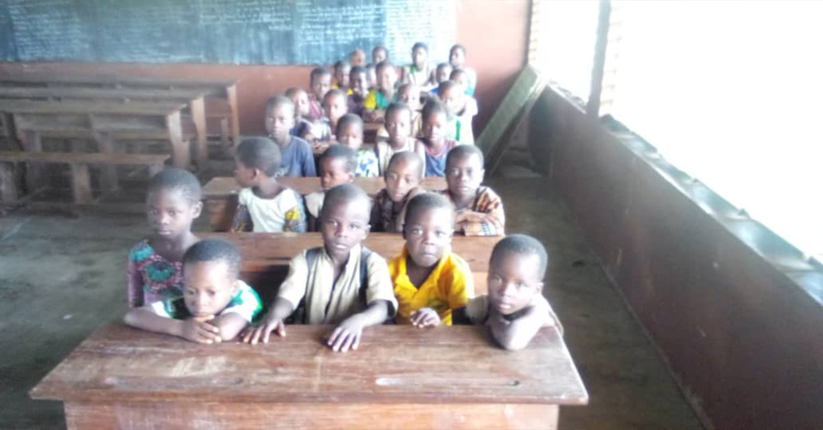 A classroom of Benin children sitting at their school desks.