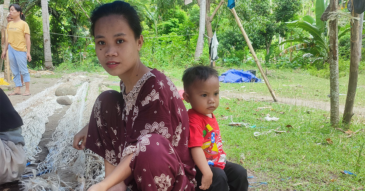 A Indonesian woman spinning rope outside.