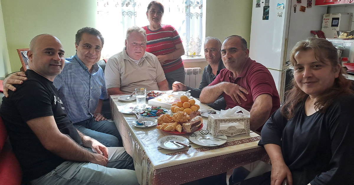 The TCD group of Armenia around a small table.