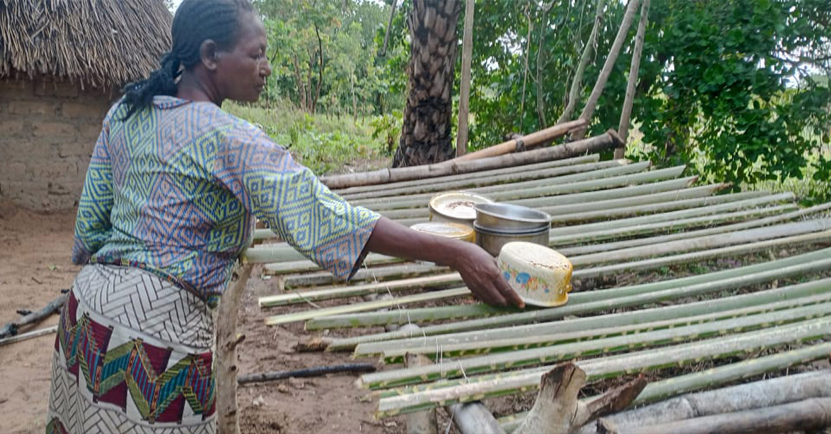 A Nigerian woman placing dishes on a newly-built dishracks.