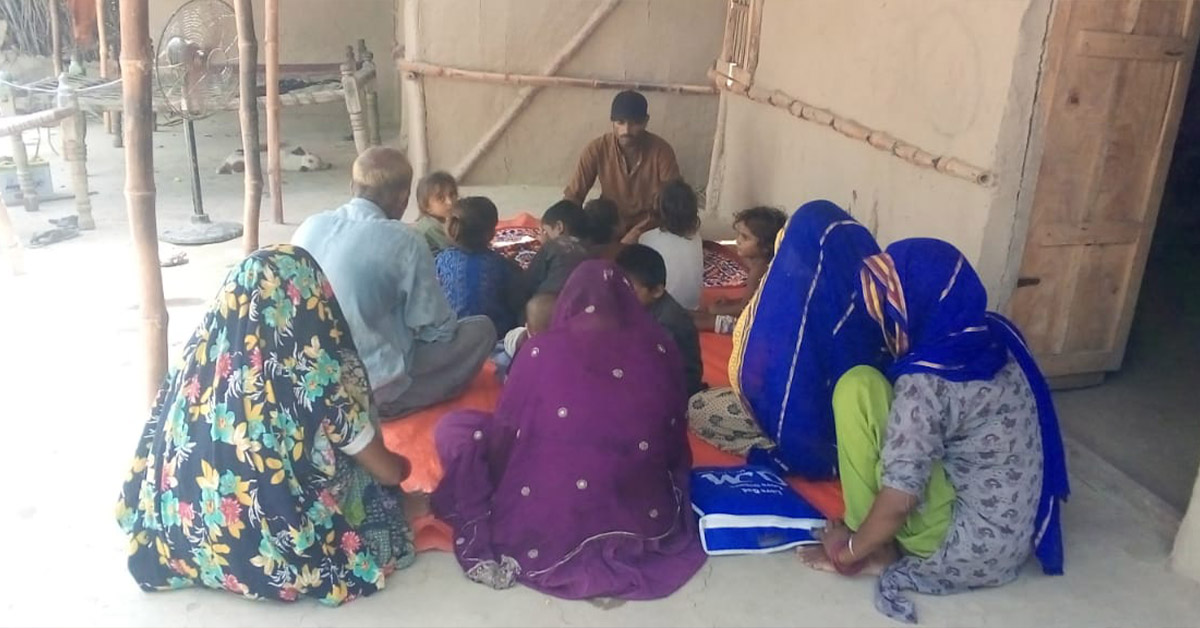 A group of villagers huddled tightly while learning about TCD.