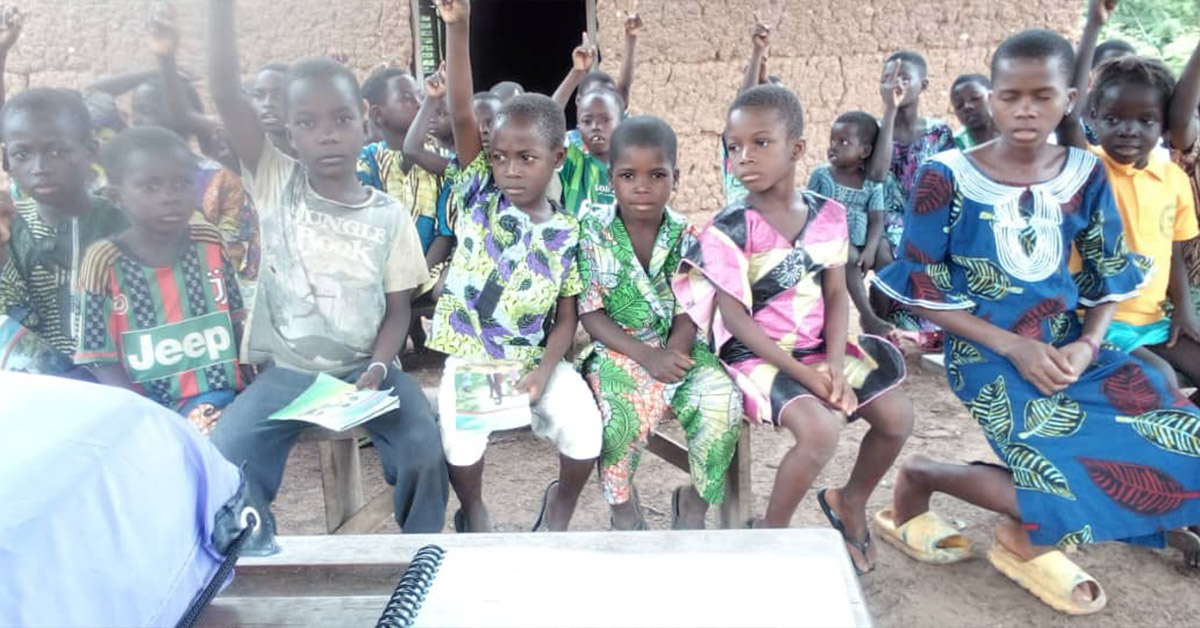 A group of Benin children sitting during literacy class.