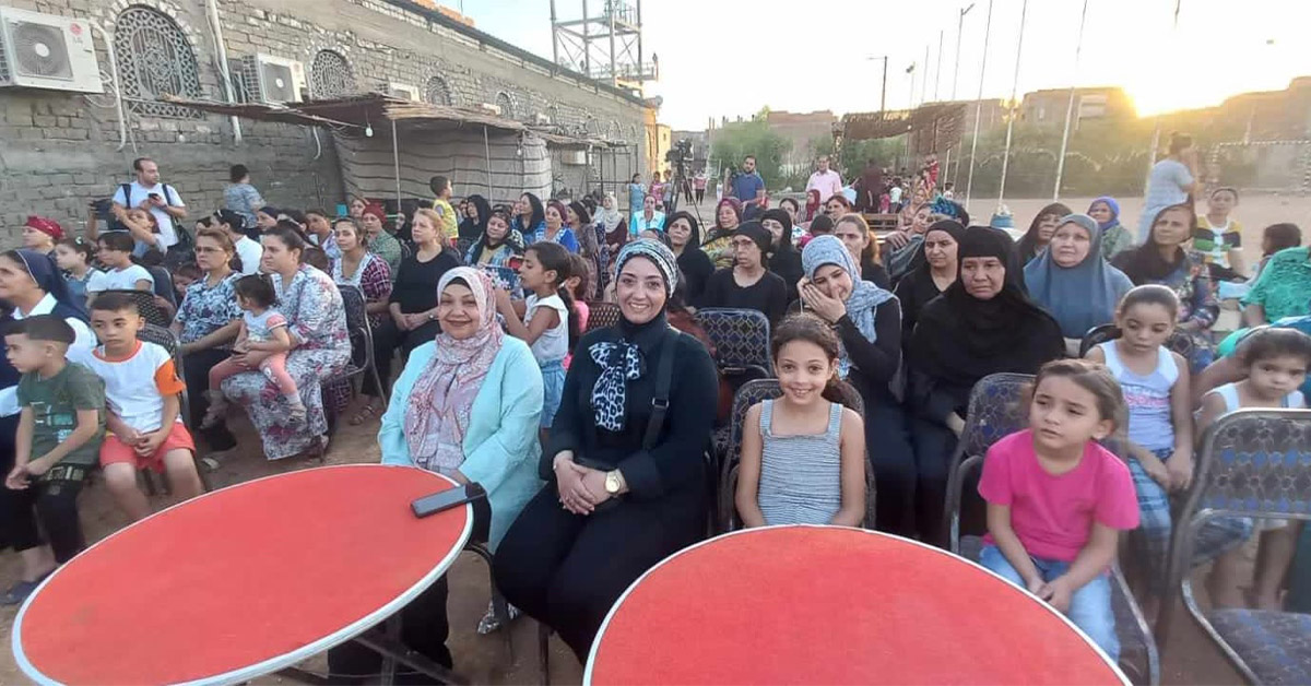 Small rows of families attending a TCD meeting outdoors.