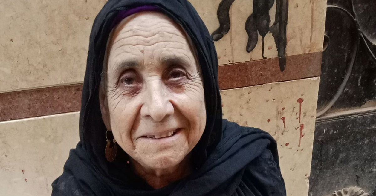 An Egyptian old lady, garbed in black, smiling.