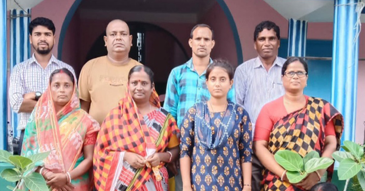 A group of Binodpur men and women in two rows, posing for a photo.