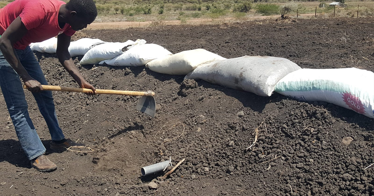 A Kenyan man preparing a part of land for gardening.