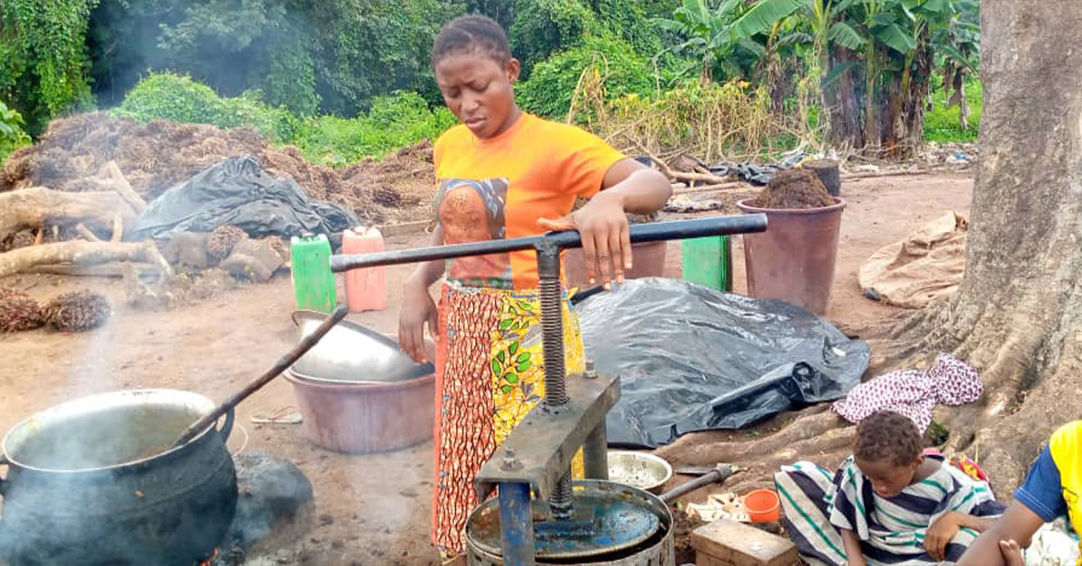 Wende using a machine for her palm oil production.