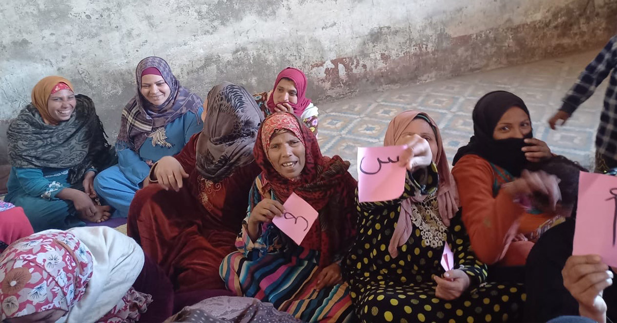 A group of Egyptian women sitting and smiling.