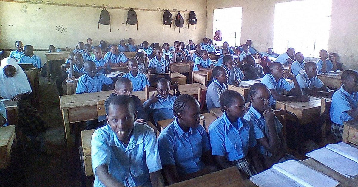 A Ntulili Junior Secondary School classroom filled with children in light blue uniforms.