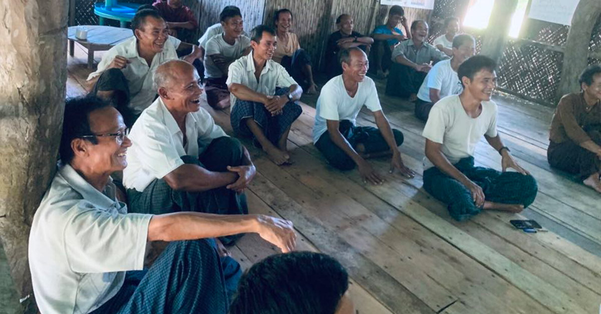 Male villagers enjoying their training lecture as they sit and listen.