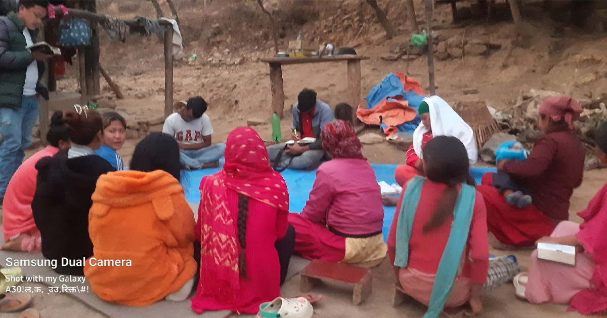 A group of villagers in a circle as they learn from a TCD worker.