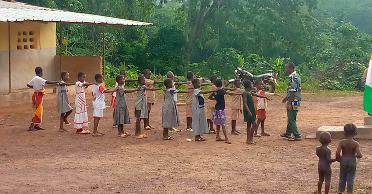 A teacher and his students conducting an after-school activity outdoors.