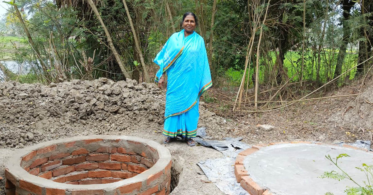 A Binodpur village lady standing in front of a newly-built well.