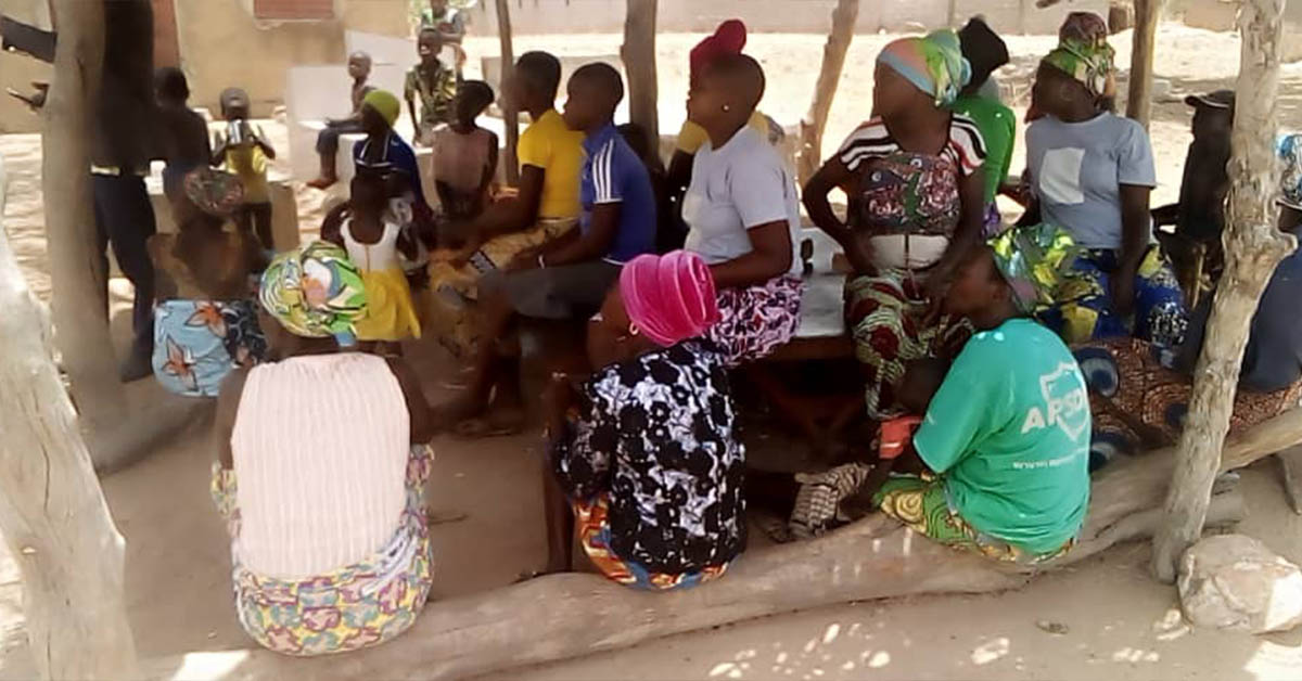 Under the shade, the women of Togo taking in a lesson.