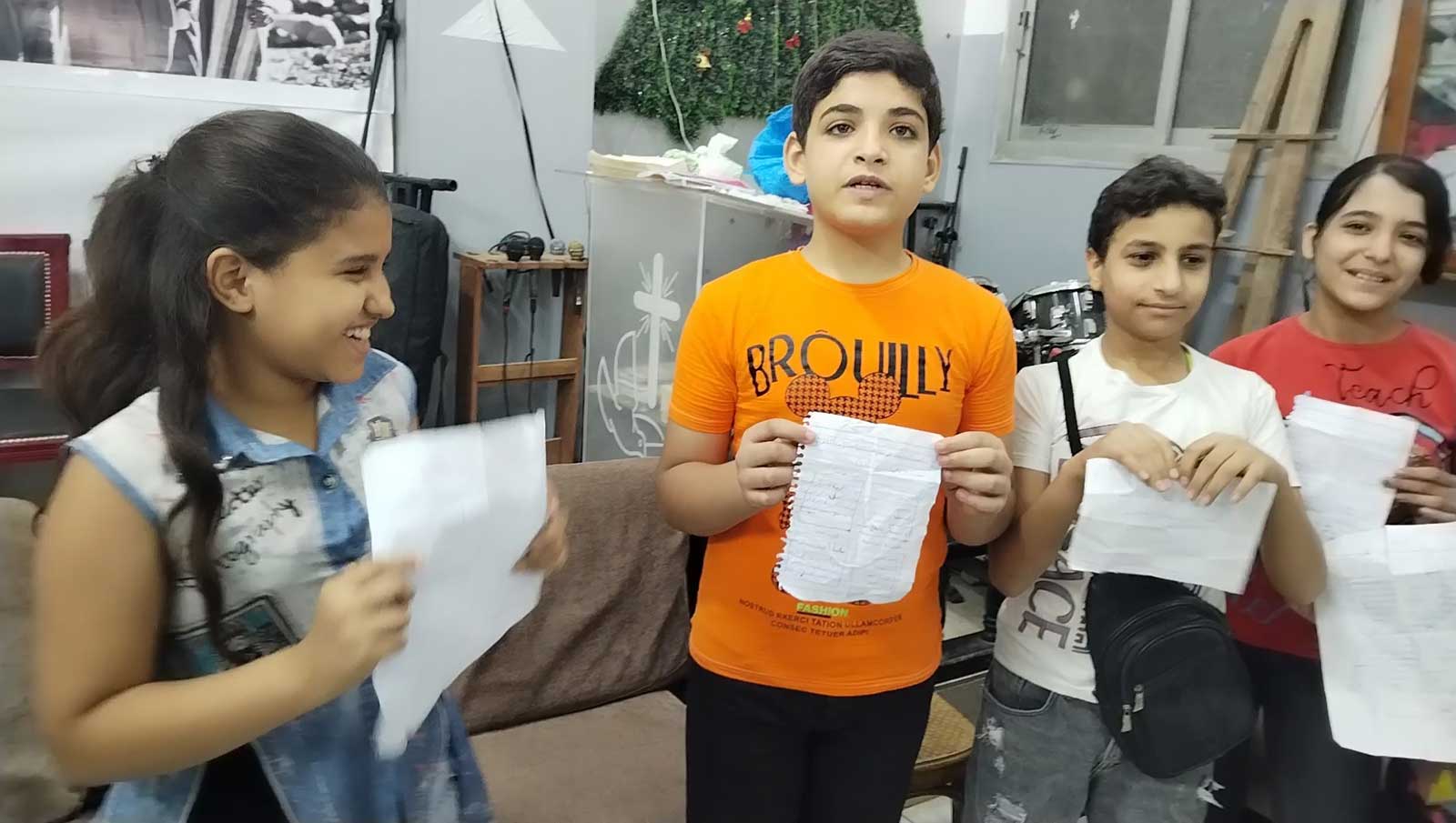 Helwan children each holding a piece of paper.