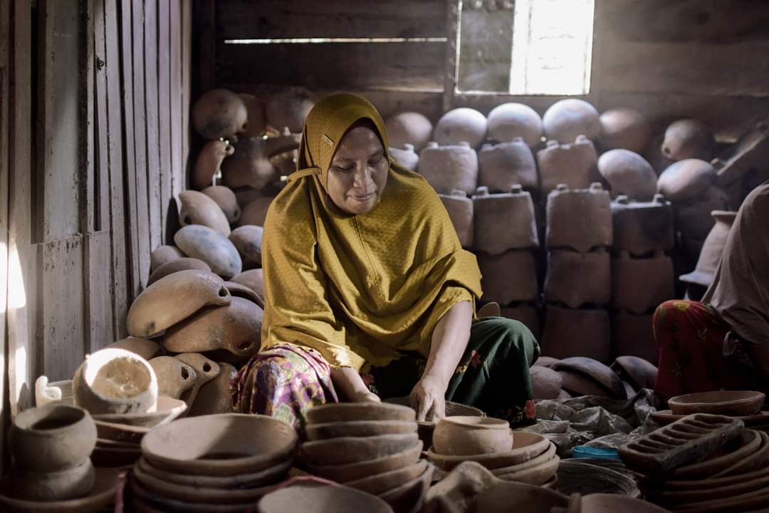 Polewali villager, Husni, at work and surrounded by her clay pots.