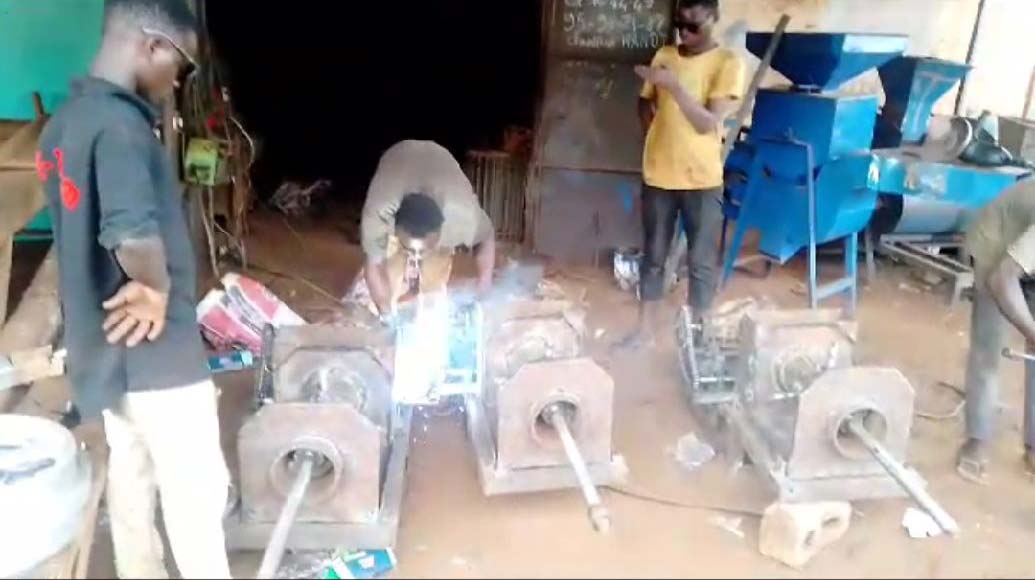 Two Benin villagers working on palm oil with their newly acquired processing machines.