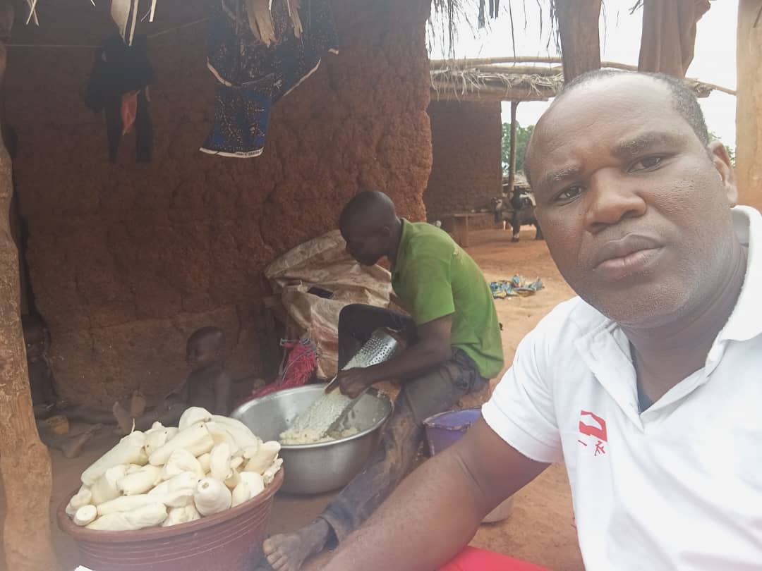 A TCD worker and villager working on the production of attieke through manual labor.