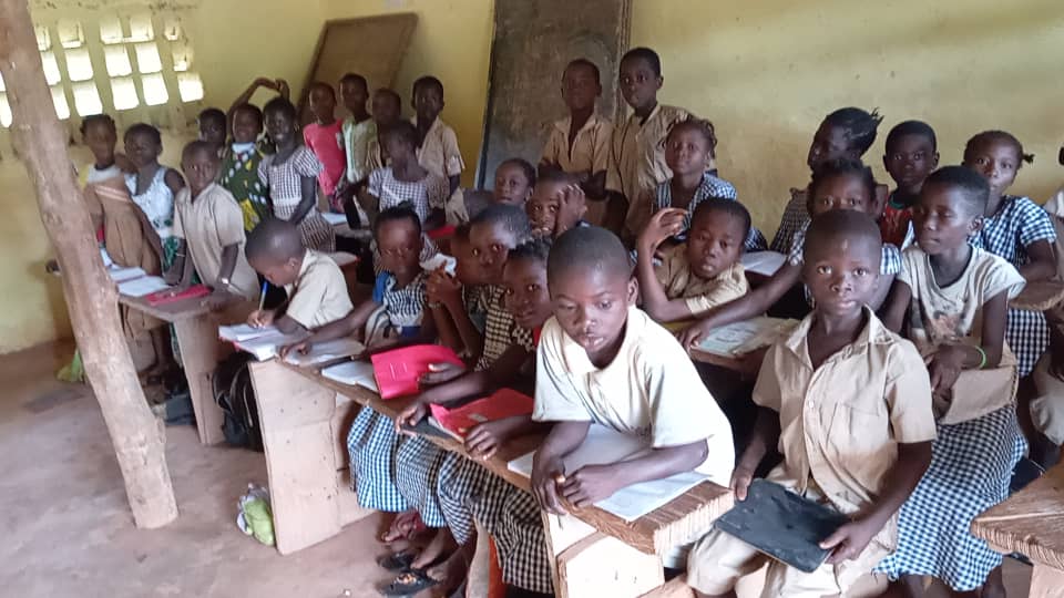 An overcrowded classroom of Attakasikoro children, with some standing in the back.