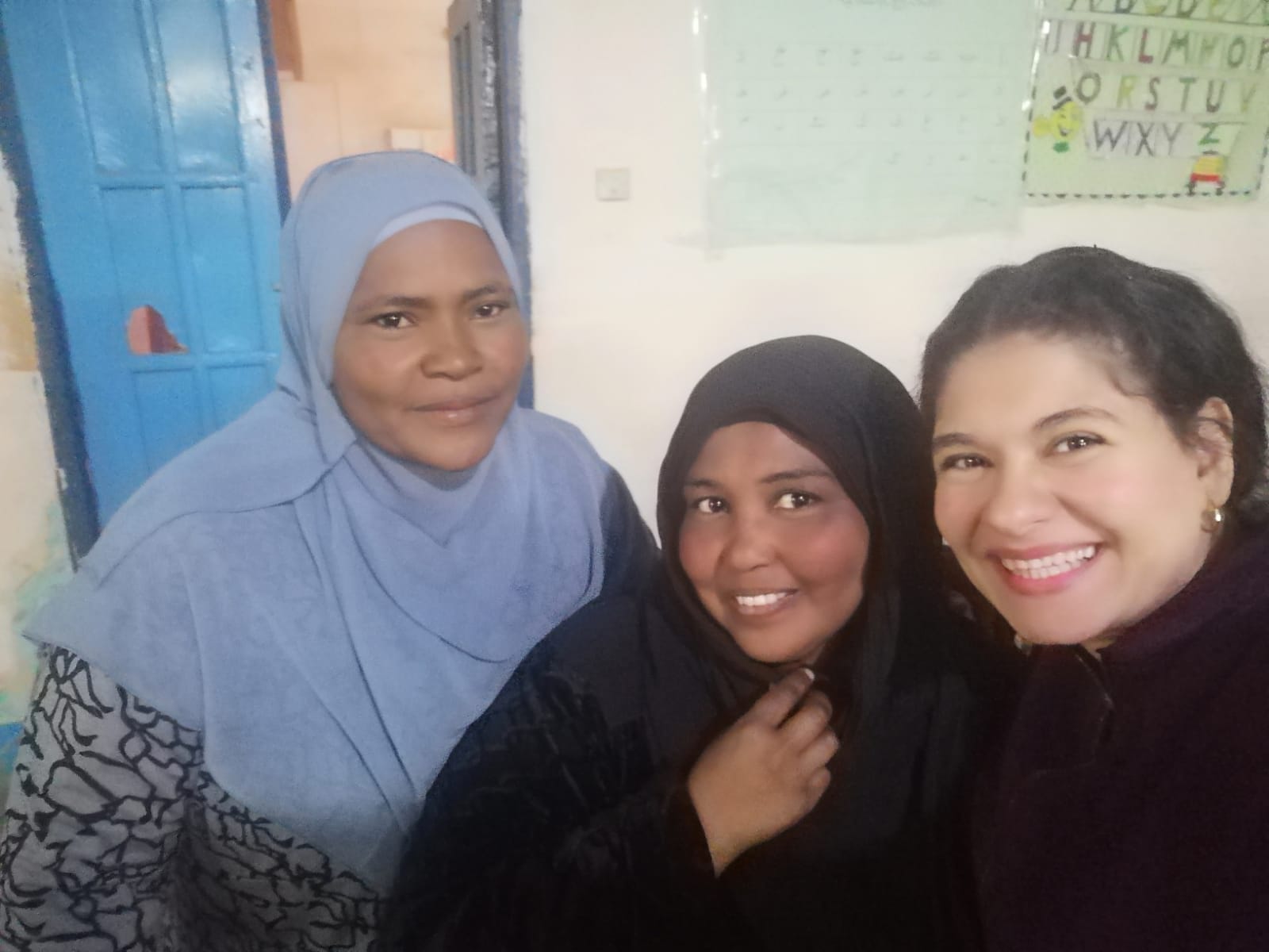 A TCD worker and two Nubian ladies posing for a selfie photo.