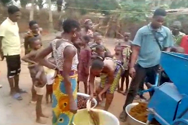Benin villagers working with their processing machine.