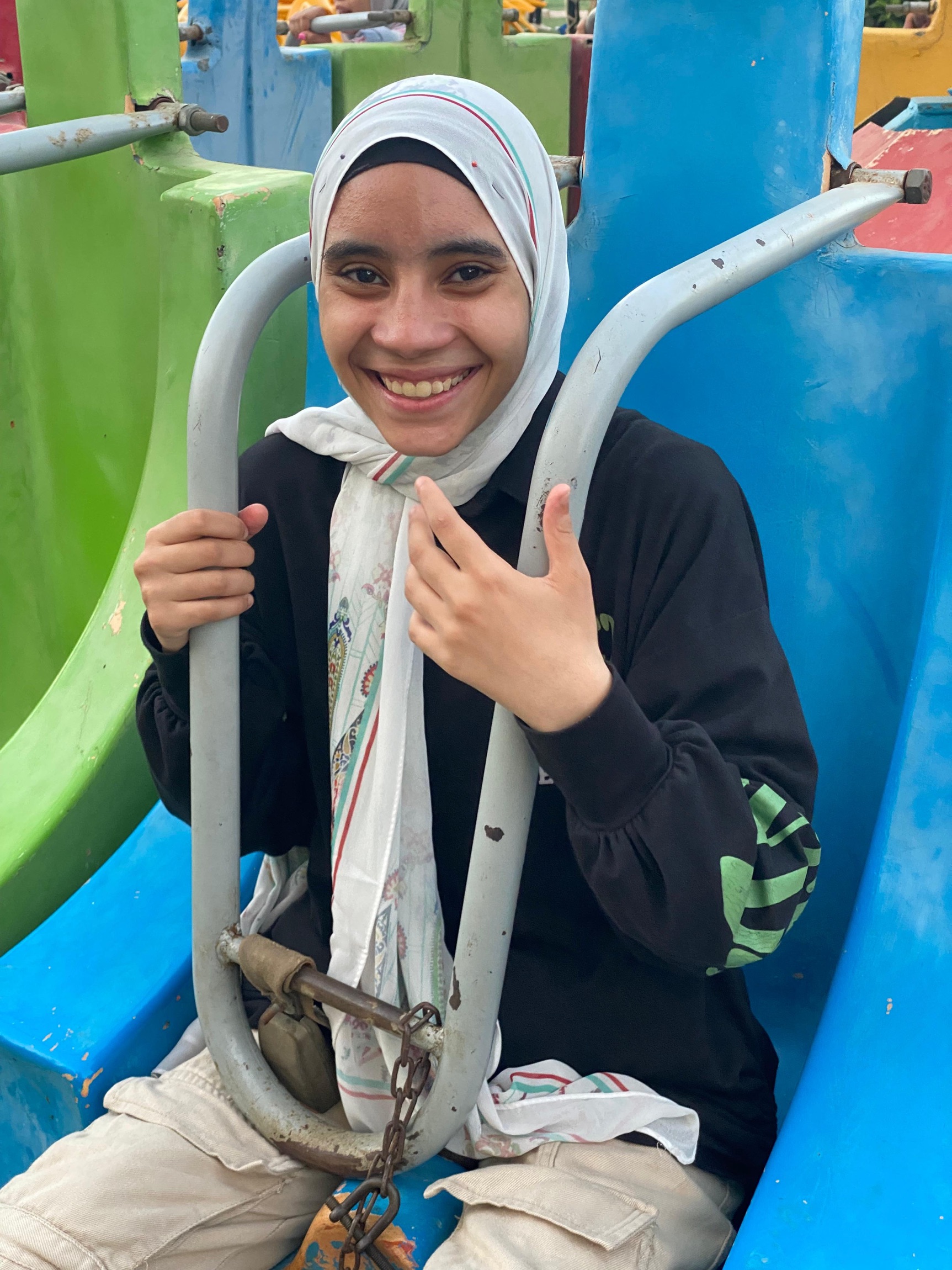 TCD attendee, Nada, smiling as she is strapped for a mechanical theme park ride.