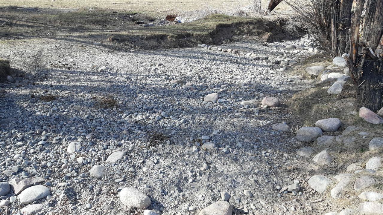 A shallow ditch with many white & grey stones.