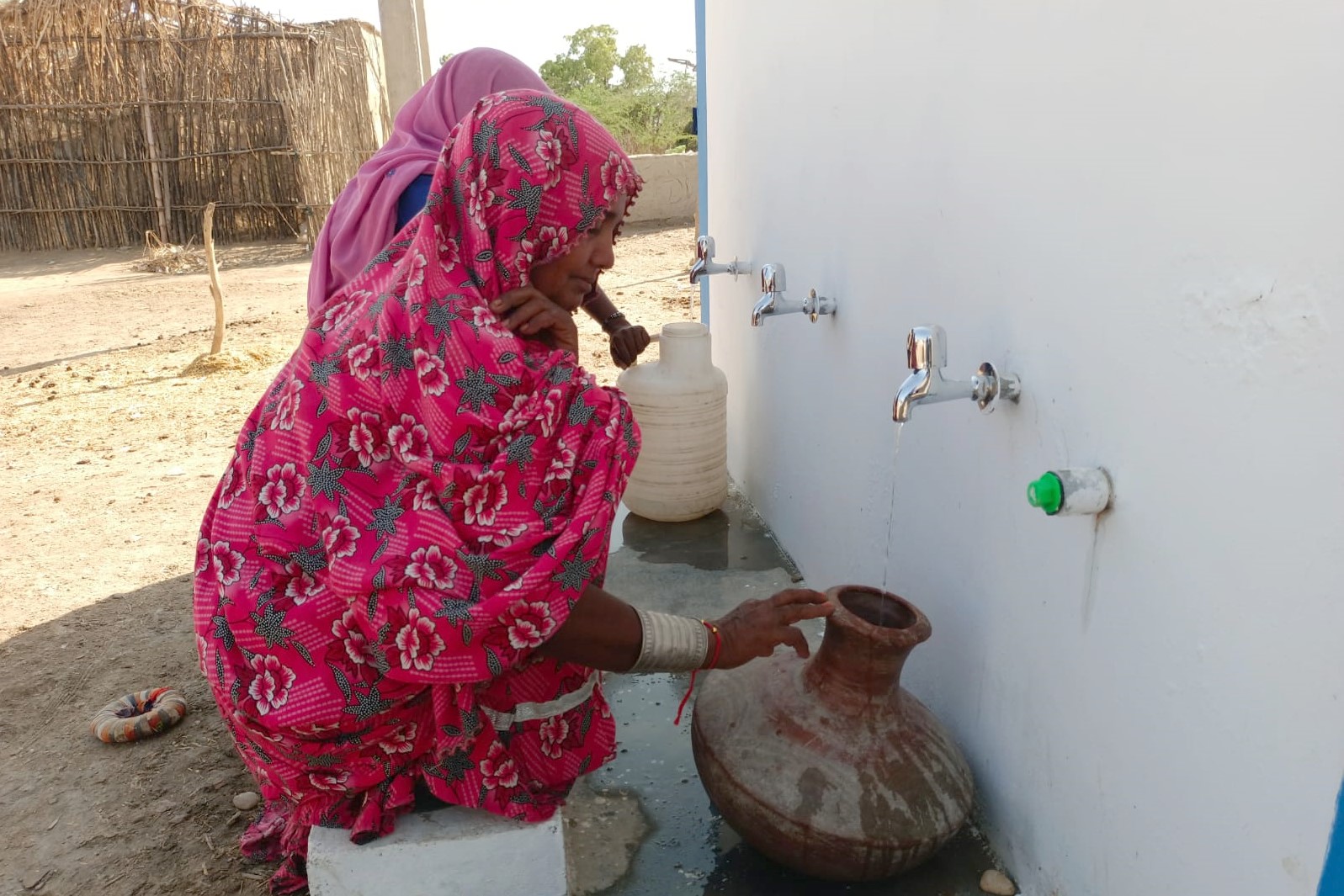 Sindh Province women using clean water stations to fill their water tanks.