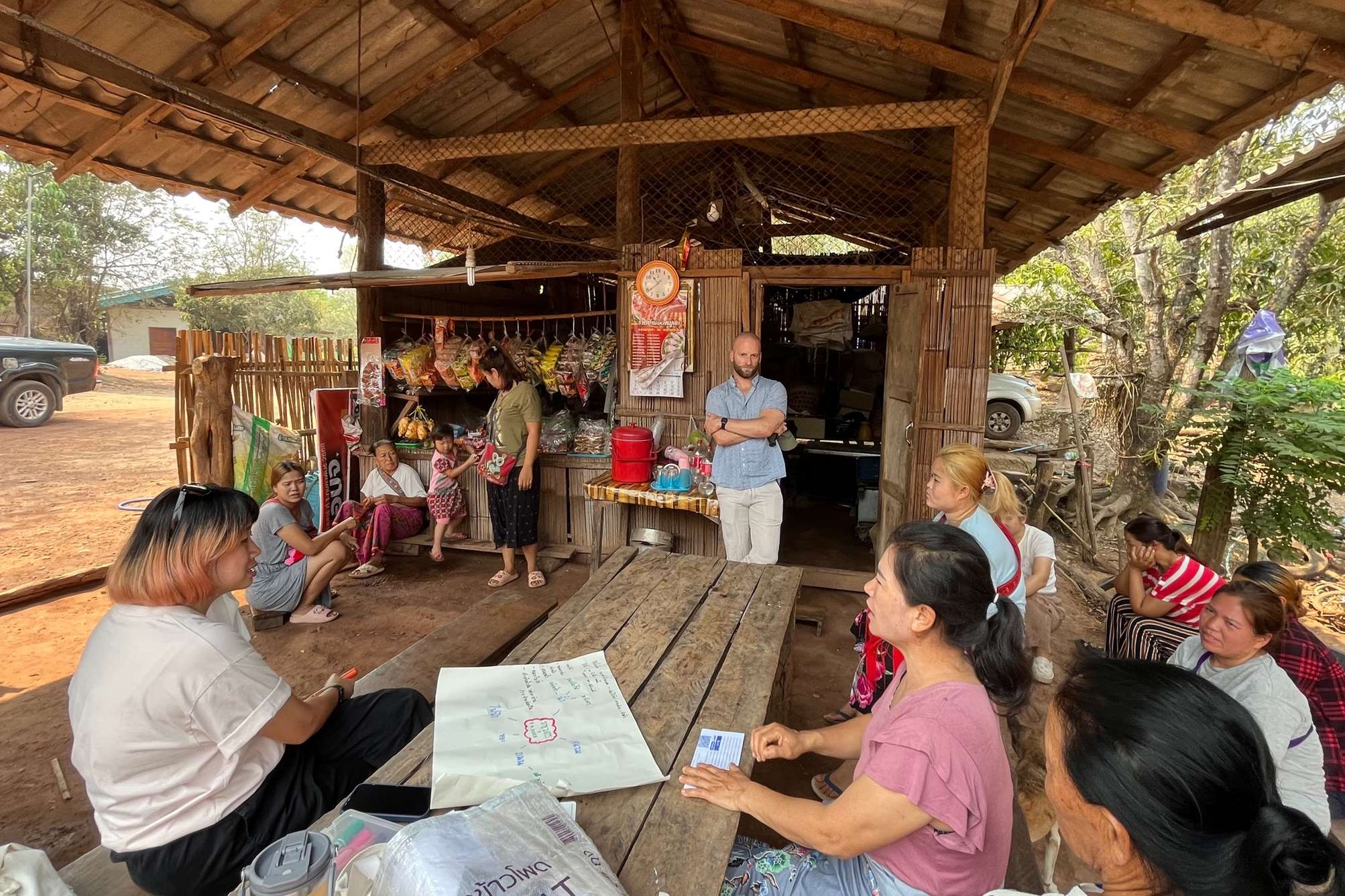 A meeting happening at a snack shop with several villagers from Ratchaboot.