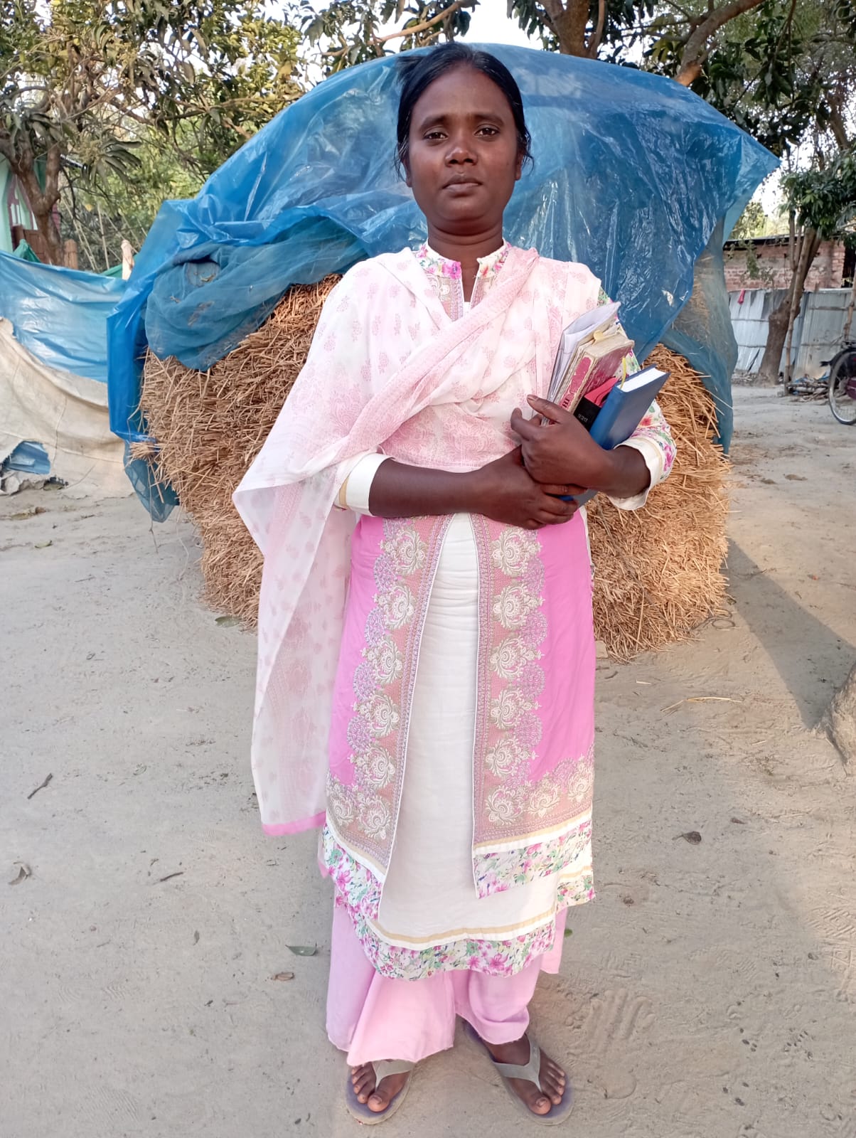 Dapur villager, Punninna Hasada, standing with her educational books.