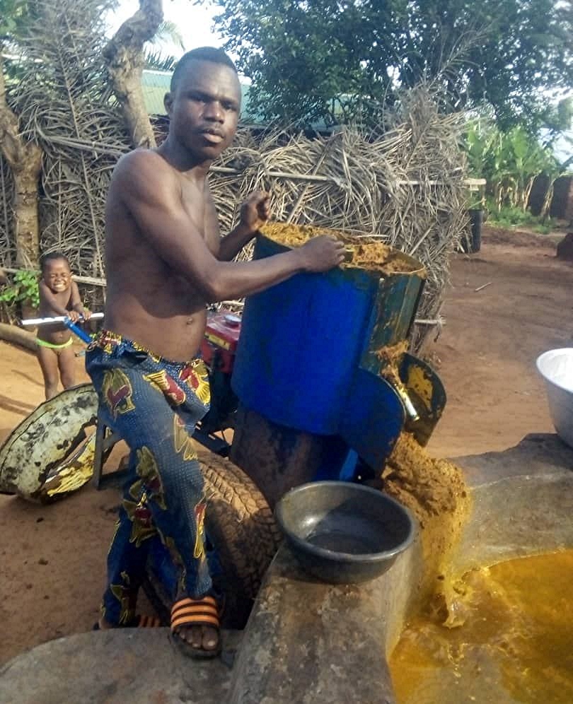 A Benin male villager posing with the portable processing machine.