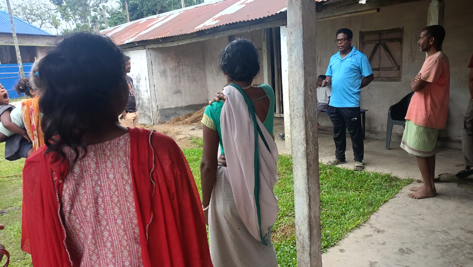 A conversation happening under the shade at a small building in the West Bengal Cluster in India.