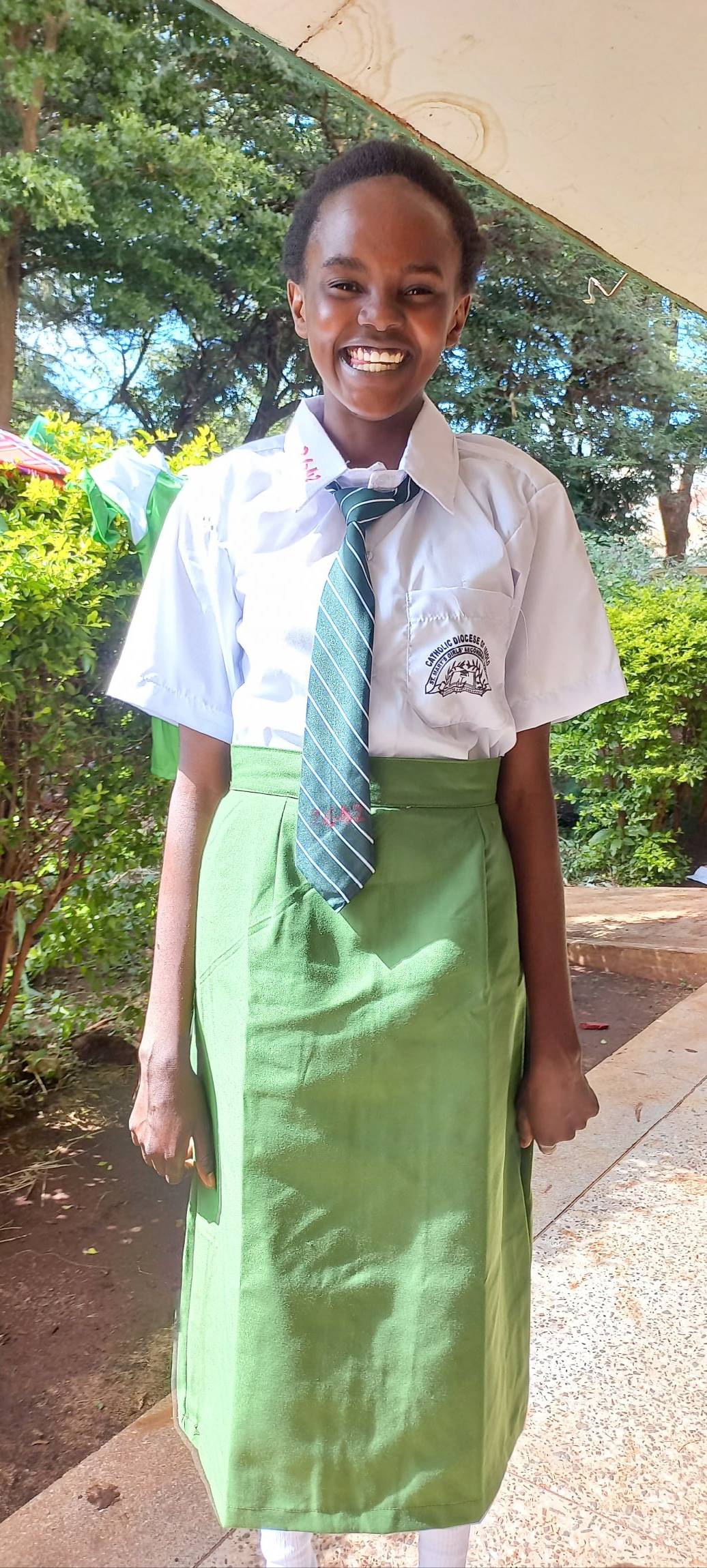 Kiwanjani villager, Risper, in her vibrant, green school uniform.