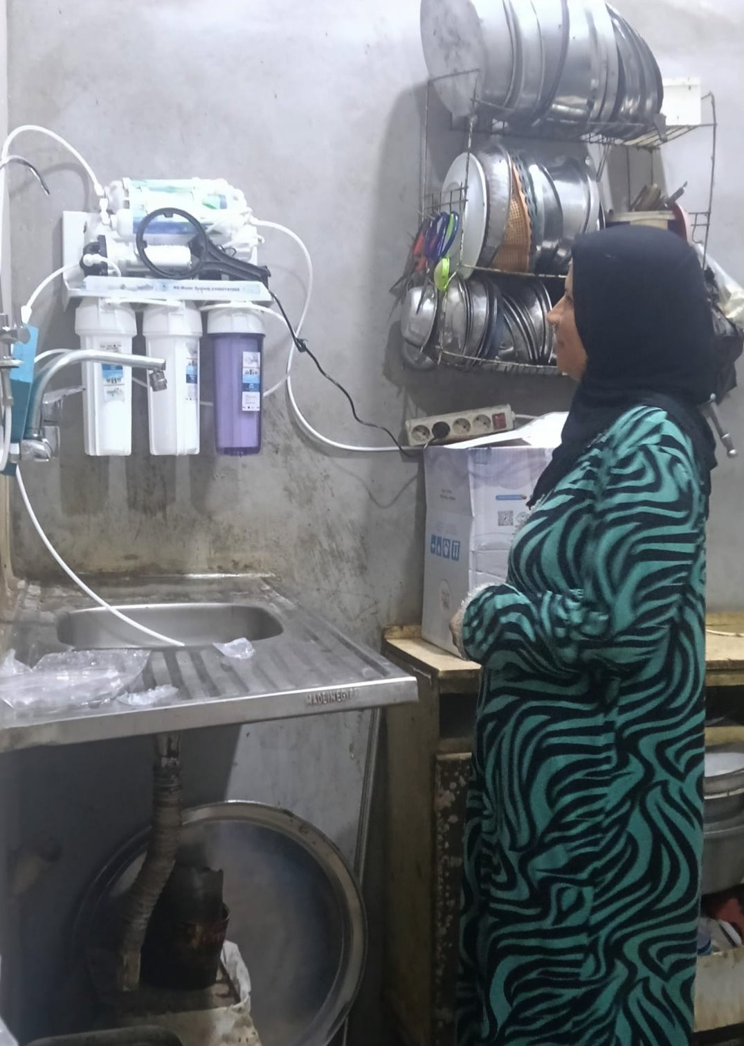 Upper Egypt Village Cluster villager, Umm Israa, seeing her new water filter.